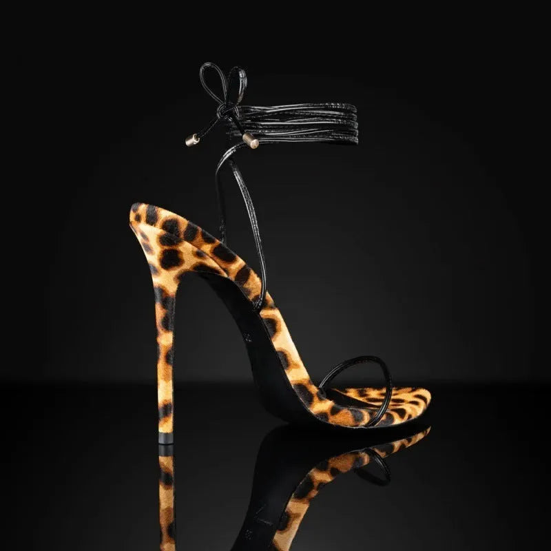 Women's leopard print Roman sandals with a pointed toe and lace-up buckle strap on a rubber sole.