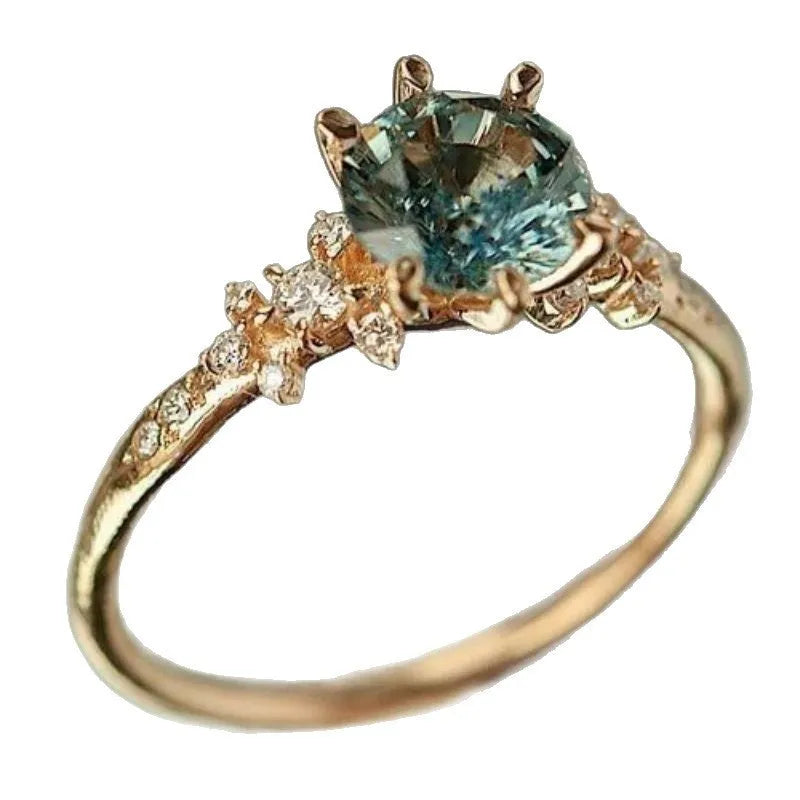 Gold coloured geometric ring with a claw-set zircon stone and chamfered square pattern.