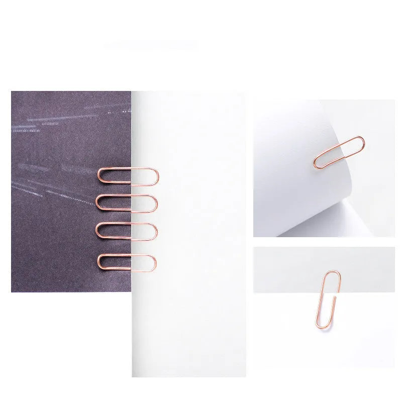 Box of 100 rose gold heart-shaped steel paper clips on a white background.