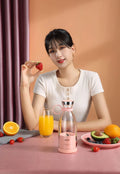 Handheld mini electric juicer in pink with USB charging cable