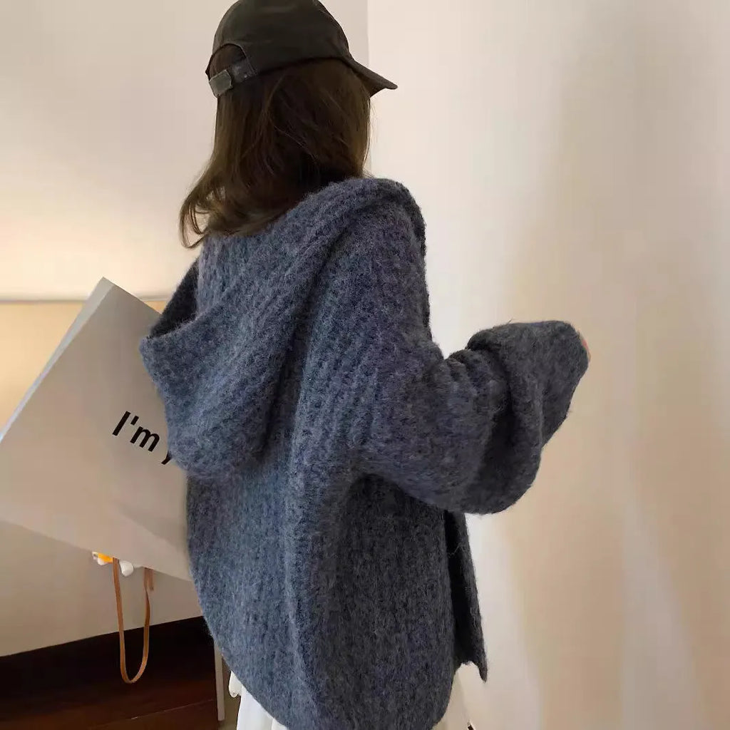 A woman wearing a brown retro-style hooded cardigan with thick knit fabric.