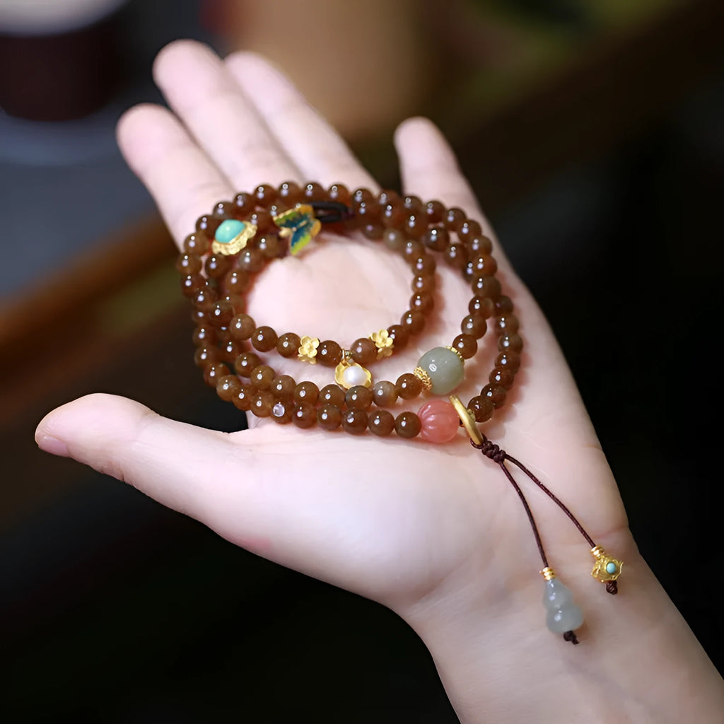 Brown Jade Hetian jade bracelet with butterfly, gourd, and pearl three-ring design and silver-plated fittings.