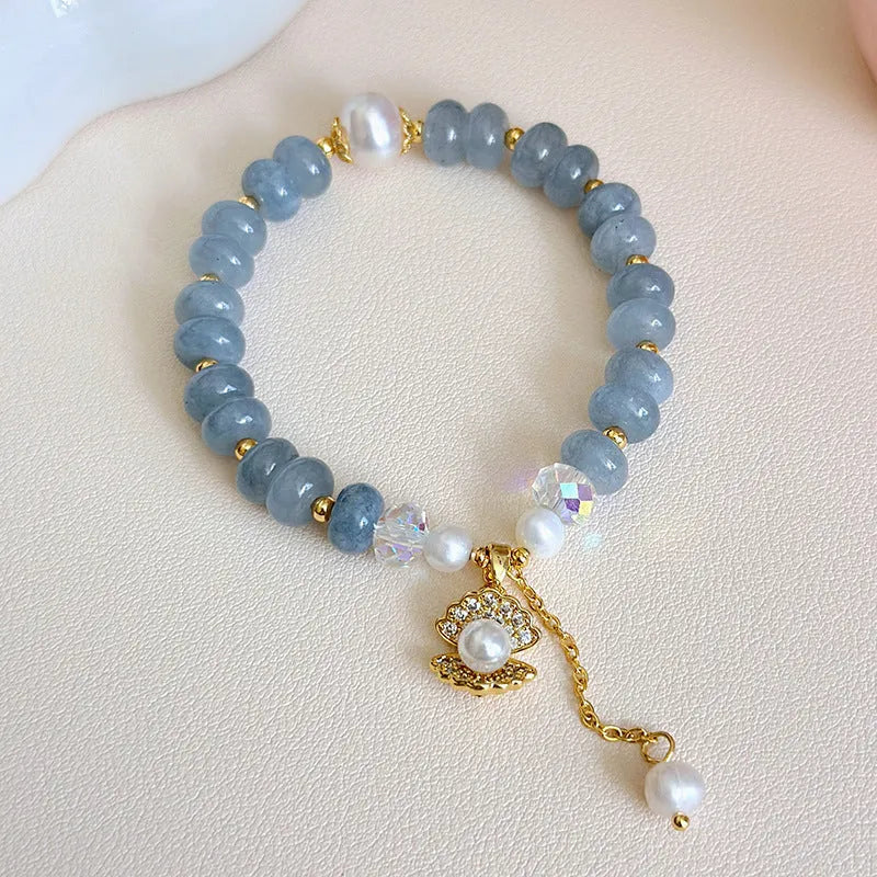 Natural aquamarine pearl shell bracelet on wrist showing adjustable design and handcrafted bead details