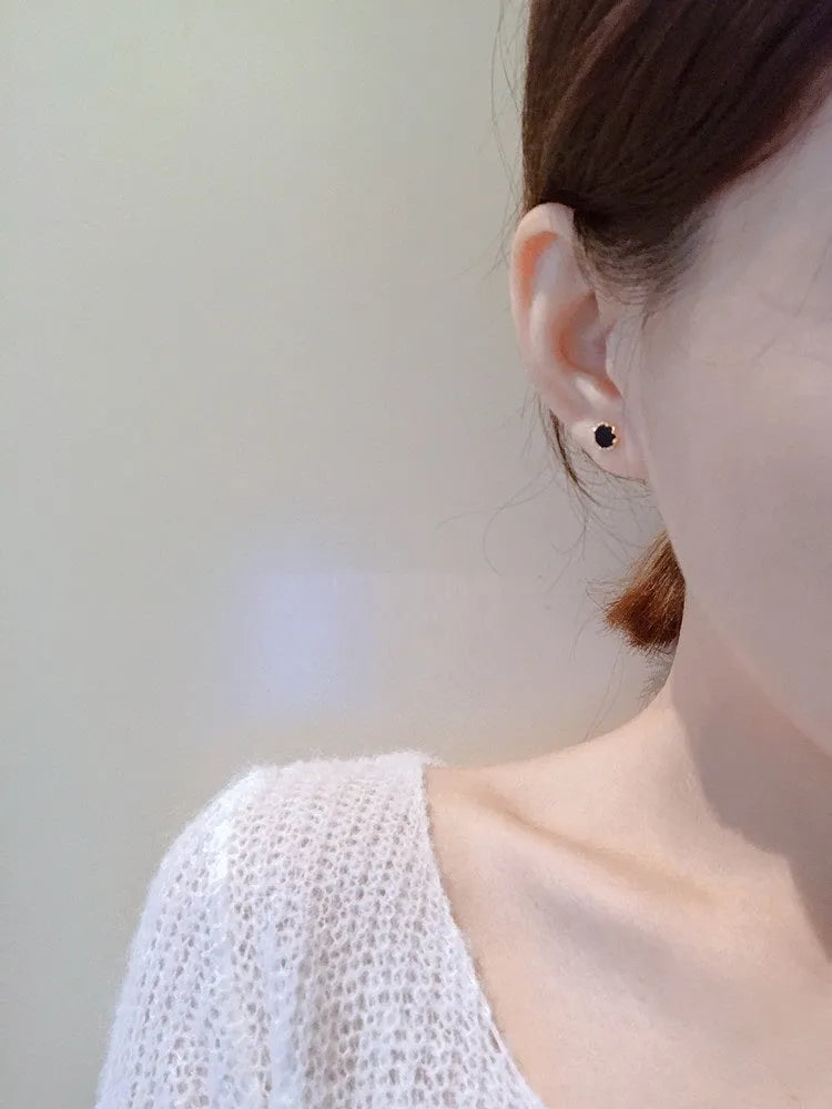 Black round mini ear studs in sterling silver plating with inlaid zircon on white background