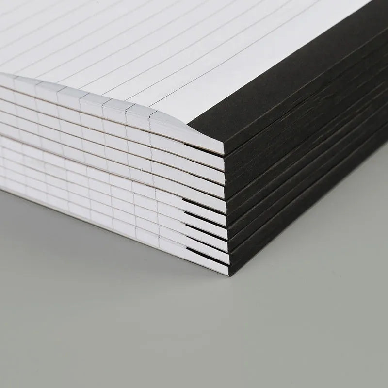 A4 tearable notebook with a paper cover, open to show ivory white gridded pages.