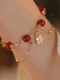 Red agate double layer bracelet with floral and peach blossom detailing on woman's wrist