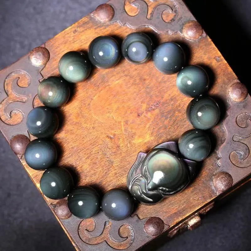 Obsidian stone bracelet with carved fox design in cartoon style, showing dark stone colouration