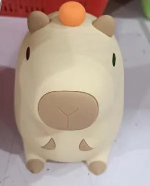 Small grey capybara-shaped silicone night lamp on a table.