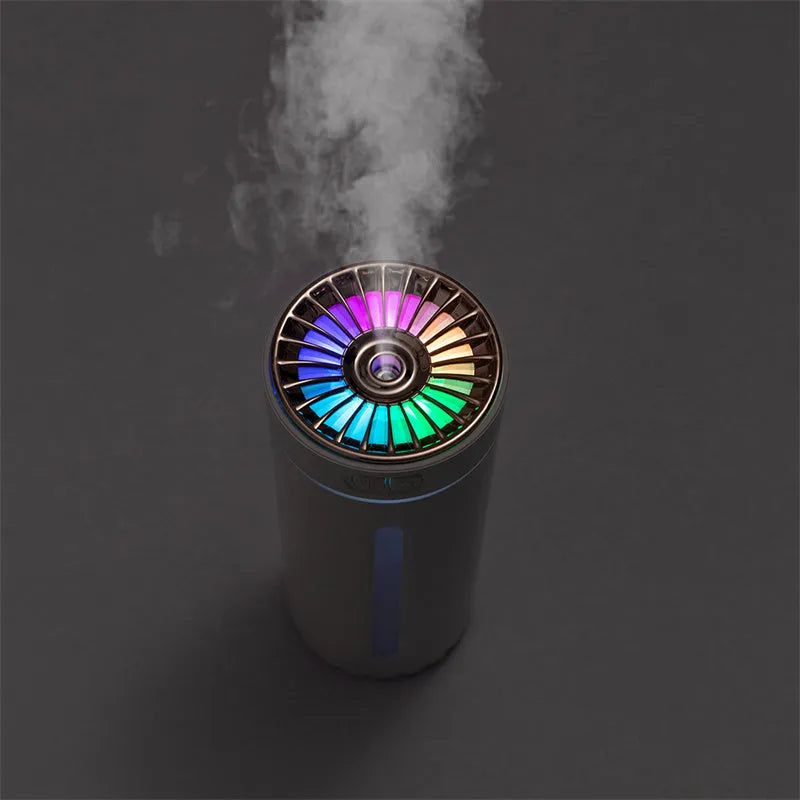 Black portable ultrasonic humidifier with colourful LED lights on a car cup holder.