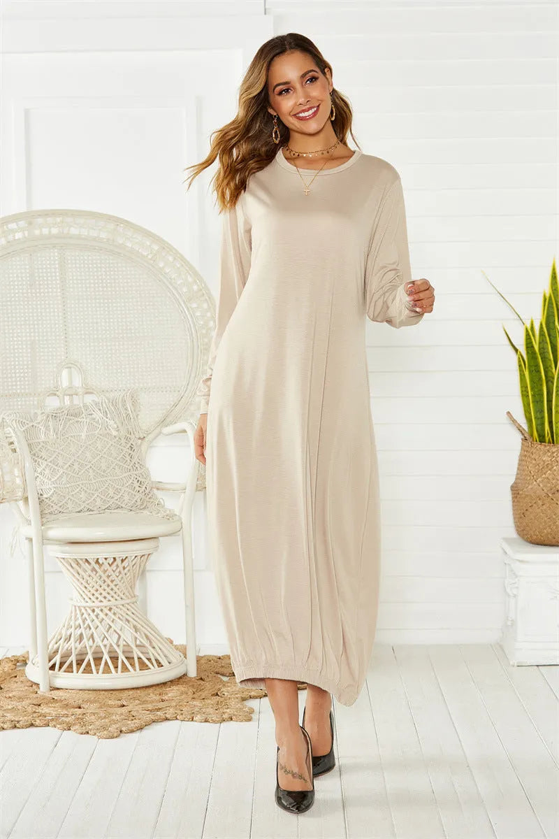 A loose, long black lantern dress with a lace-up crew neck on a mannequin.