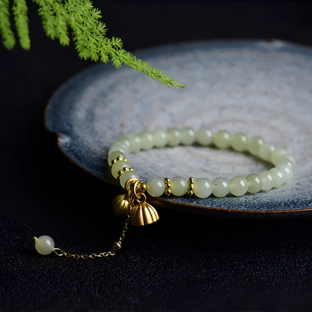 Two Shihuan natural Hetian jade bracelet with 6mm beads, fu charm, and lotus motif on a wrist.