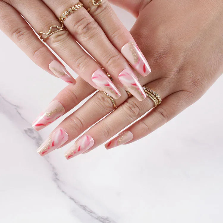 Set of medium-length false nails showing rose, tulip, leopard print, and XINGX patterns with glue.