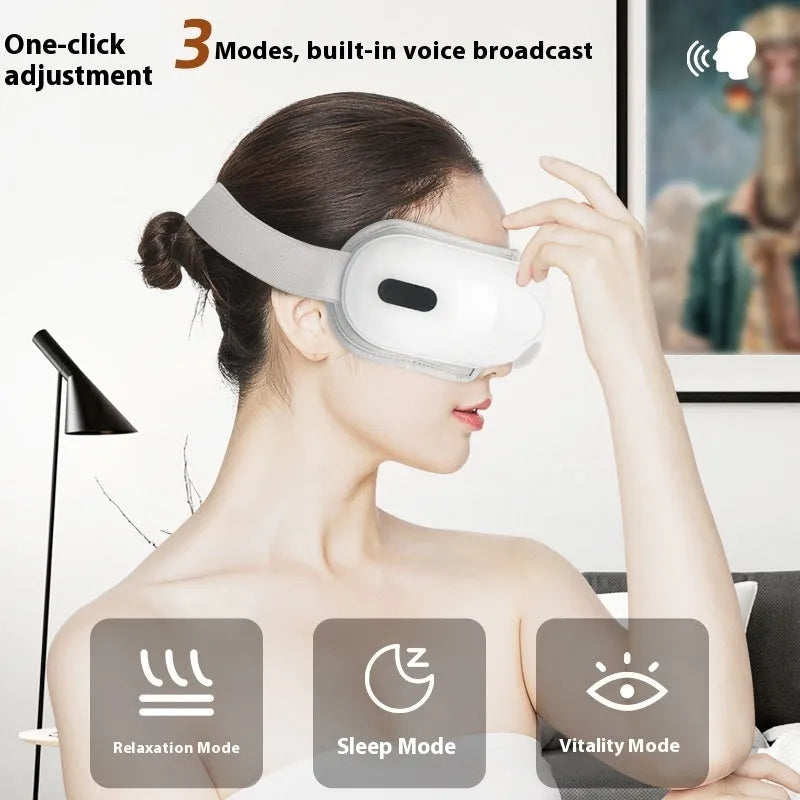 White rechargeable eye massager with hot compress and airbag massage functions on a table.