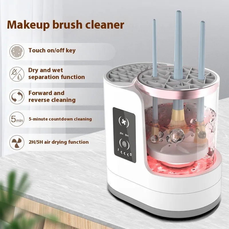 White electric makeup brush cleaner with drying chamber on a table, next to makeup brushes.