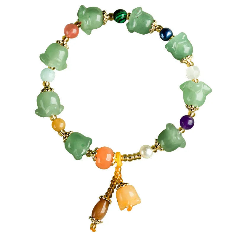 Natural Xinjiang Jinsi Jade aventurine orchid bracelet with carved orchid beads on a wrist.