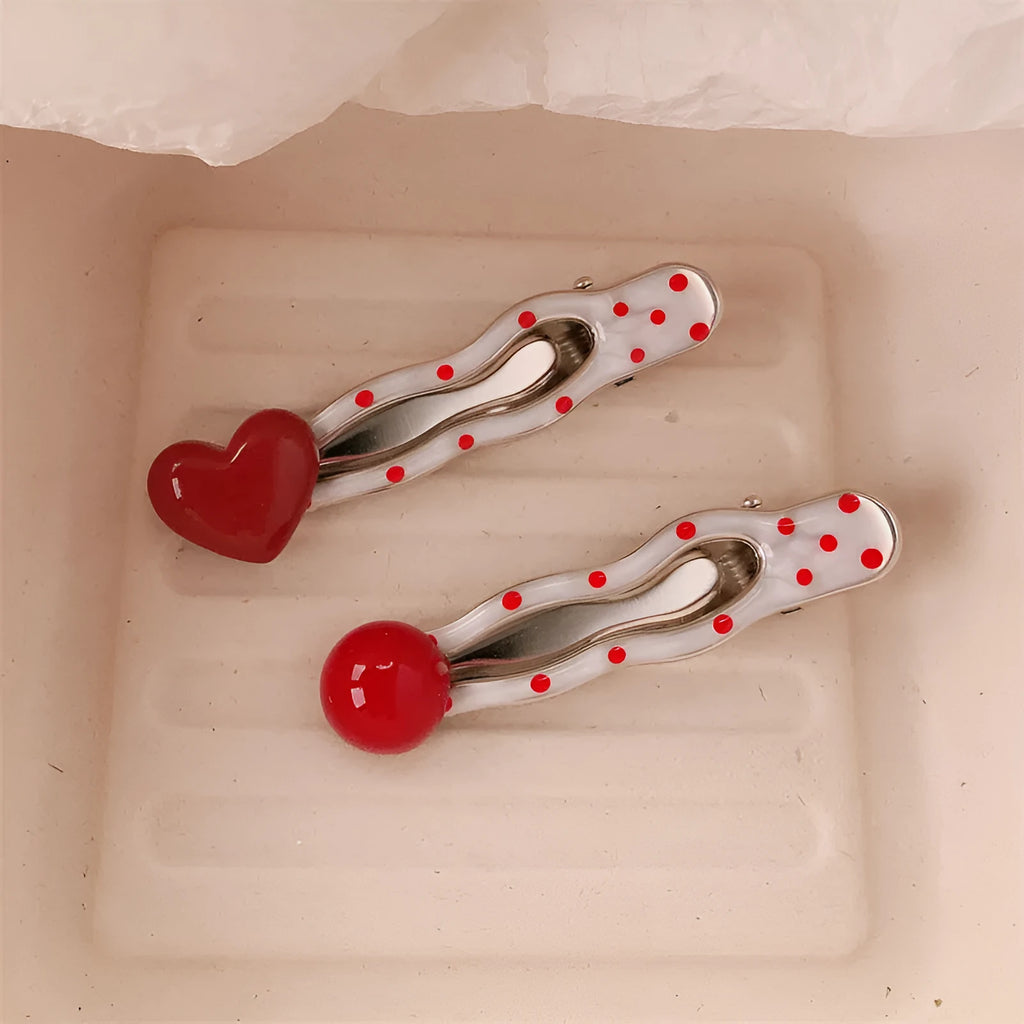 Red love heart-shaped hair clip with white polka dots and a green willow leaf decoration.