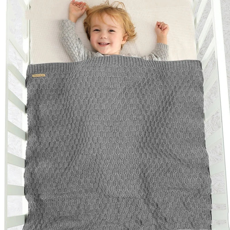 Solid colour acrylic infant blanket with textured lines, shown in a choice of five colours.