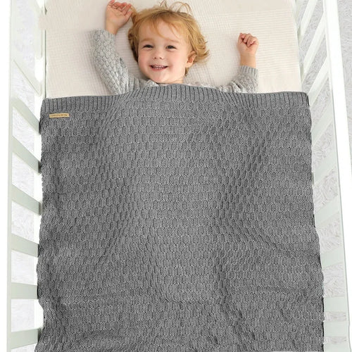 Solid colour acrylic infant blanket with textured lines, shown in a choice of five colours.